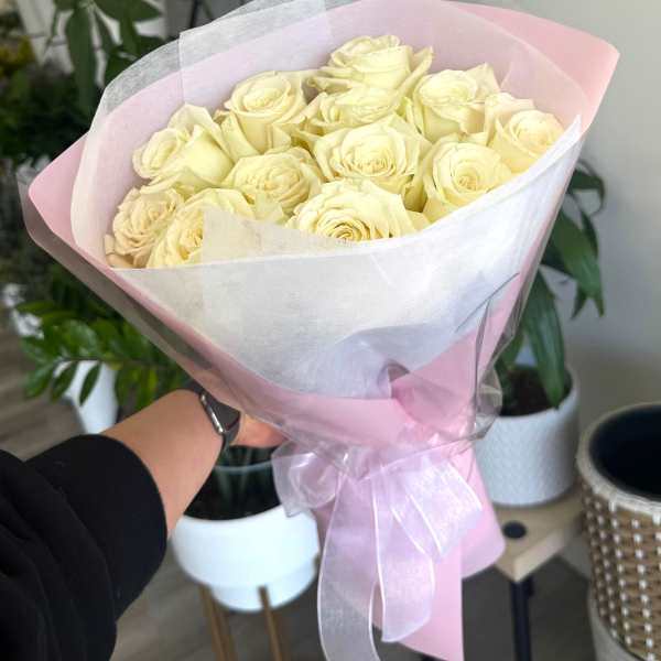Bouquet of pale cream roses wrapped in pink and white paper