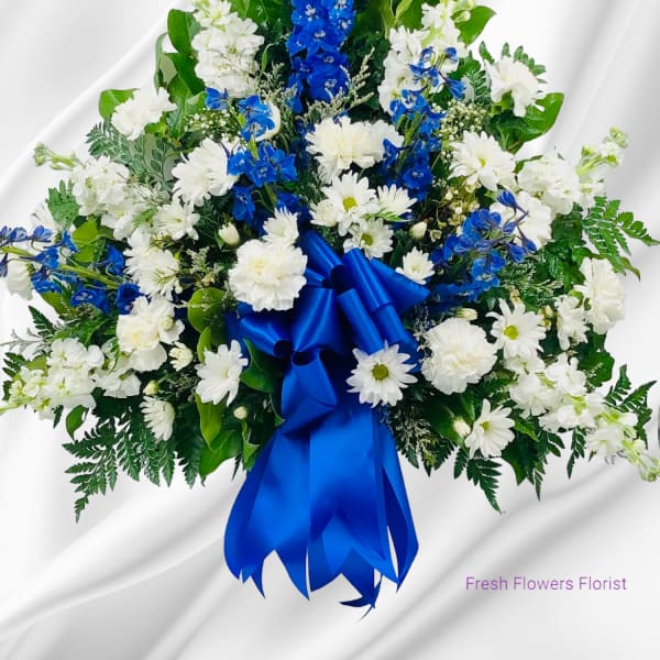 White and blue floral spray with a satin ribbon bow