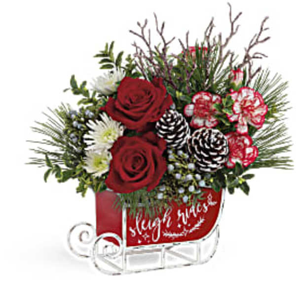 Red roses and white flowers in a red sleigh-shaped container