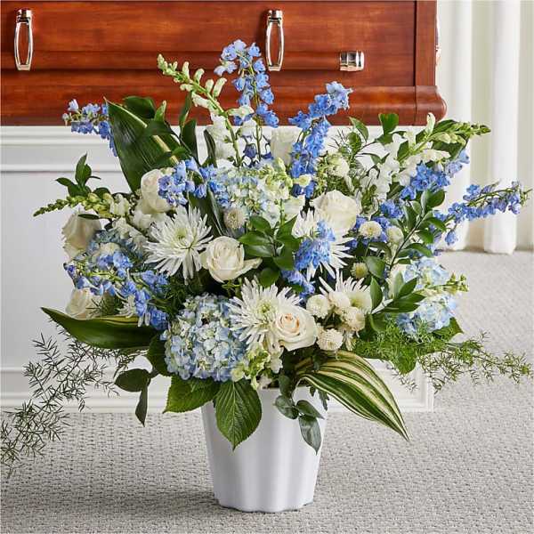Blue and white floral arrangement in a white vase