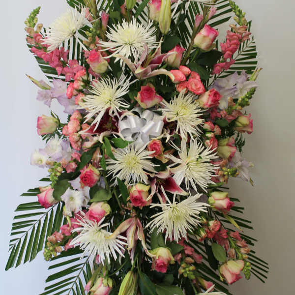Standing floral spray with pink roses, white spider mums, and lilies