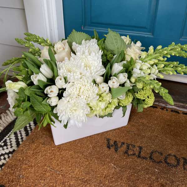 White floral arrangement in a rectangular white container