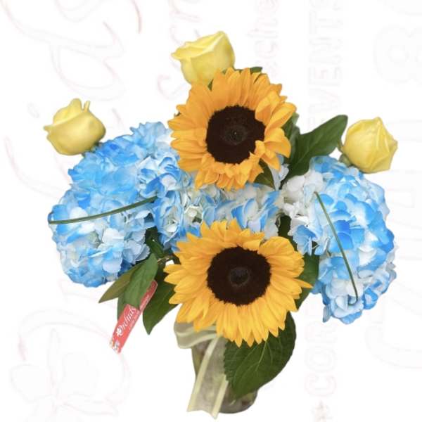 Bouquet of blue hydrangeas with yellow roses and sunflowers in a vase