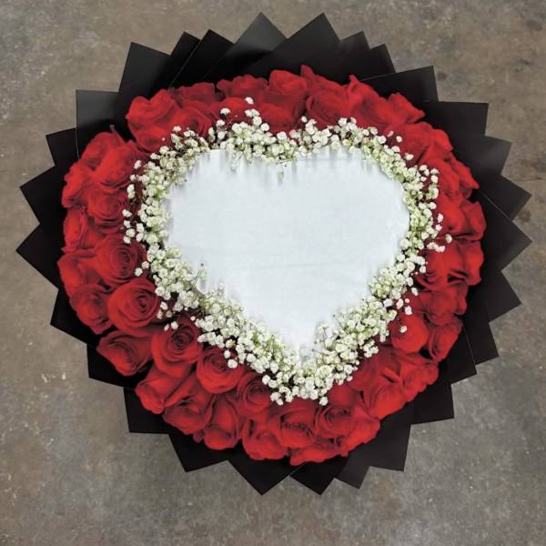 Heart-shaped bouquet of red roses with white baby's breath