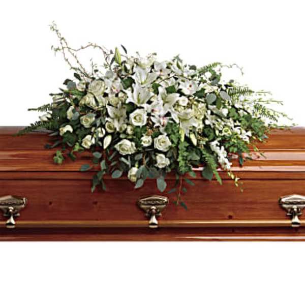 White floral spray on a wooden casket