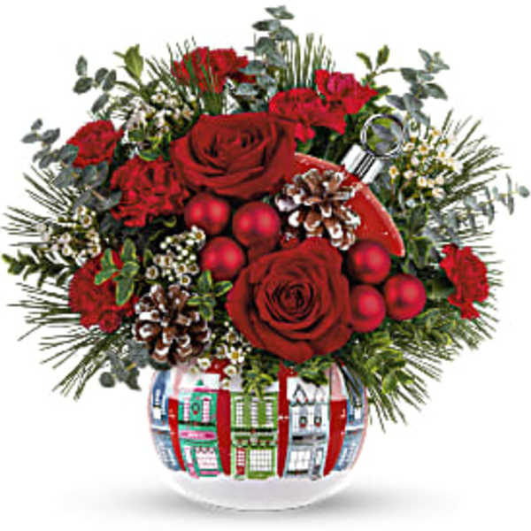 Red roses and holiday accents in a decorated glass vase