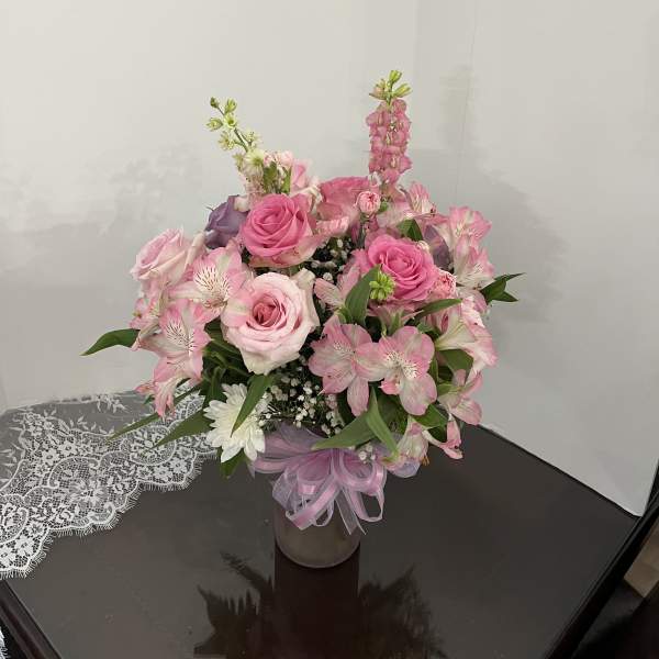 Pink rose bouquet with alstroemeria in a glass vase tied with ribbon