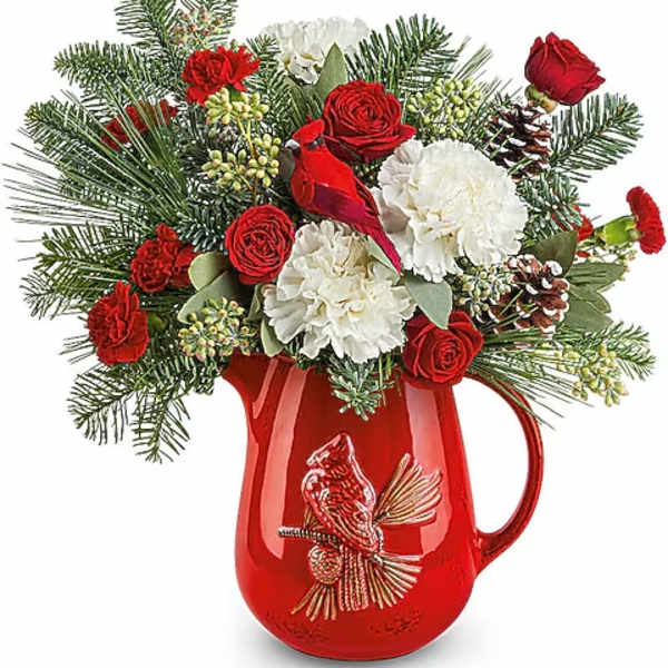 Red and white floral arrangement in a red pitcher vase