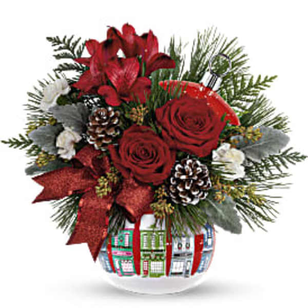 Red roses and lilies in a decorated glass vase with pinecones