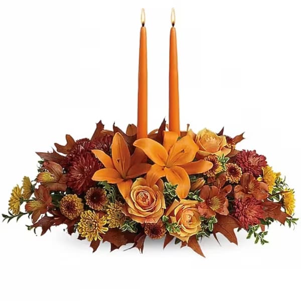 Orange floral centerpiece with two taper candles