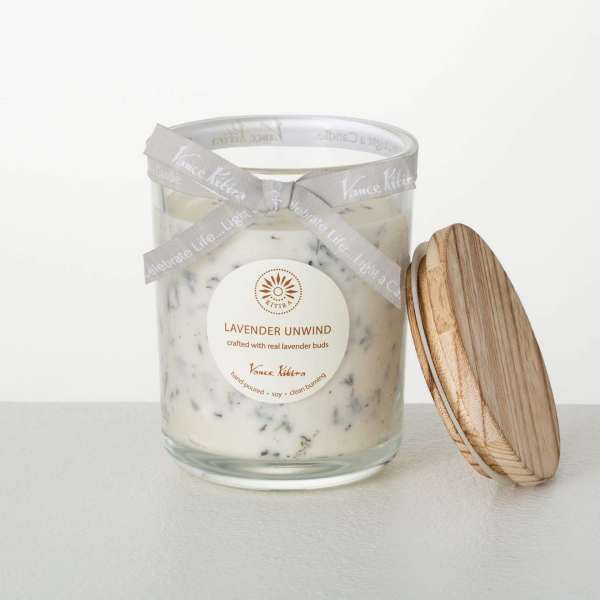White lavender-scented candle in a glass jar with wood lid and gray ribbon
