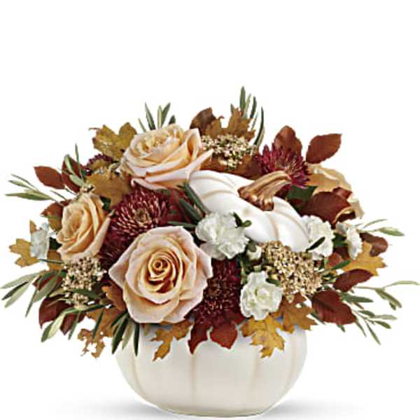 Peach roses and white flowers in a white pumpkin vase
