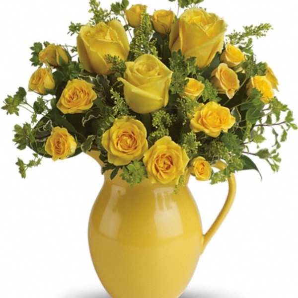 Yellow roses arranged in a yellow pitcher vase