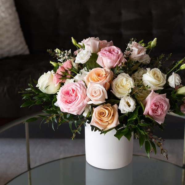 Bouquet of pastel roses in a white cylindrical vase