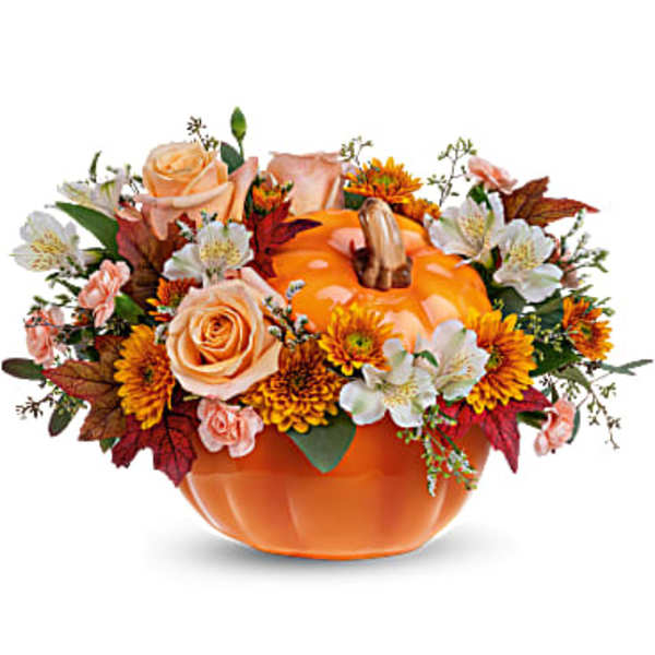Orange pumpkin-shaped vase with peach roses and autumn flowers
