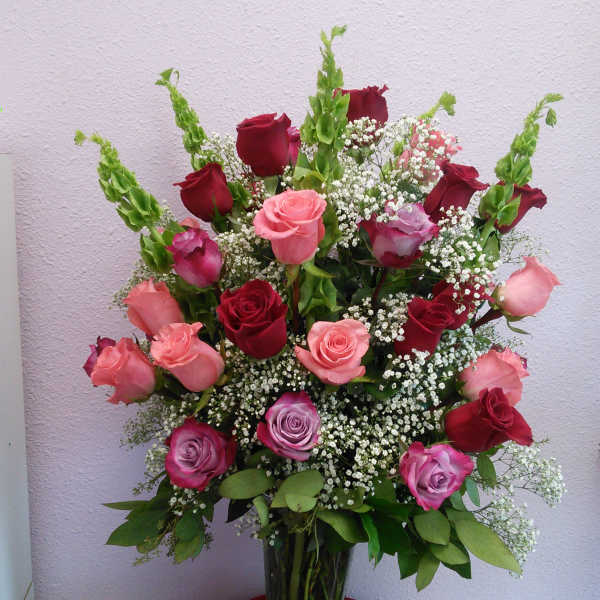Mixed roses in a clear glass vase with baby's breath
