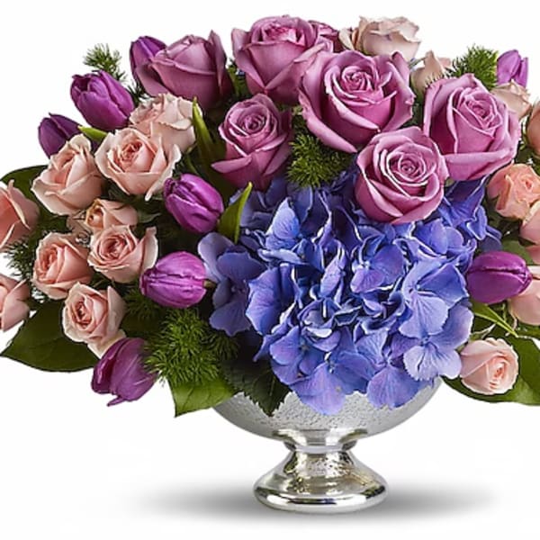 Lavender roses and blue hydrangea in a silver pedestal vase