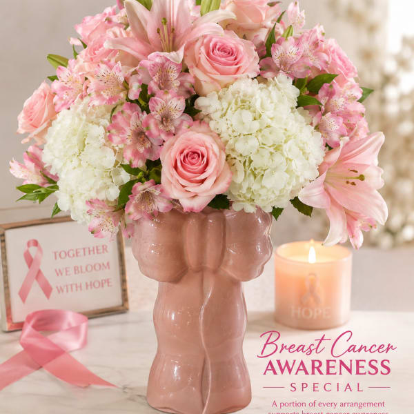 Pink and white floral arrangement in a pink vase with a candle and awareness ribbon
