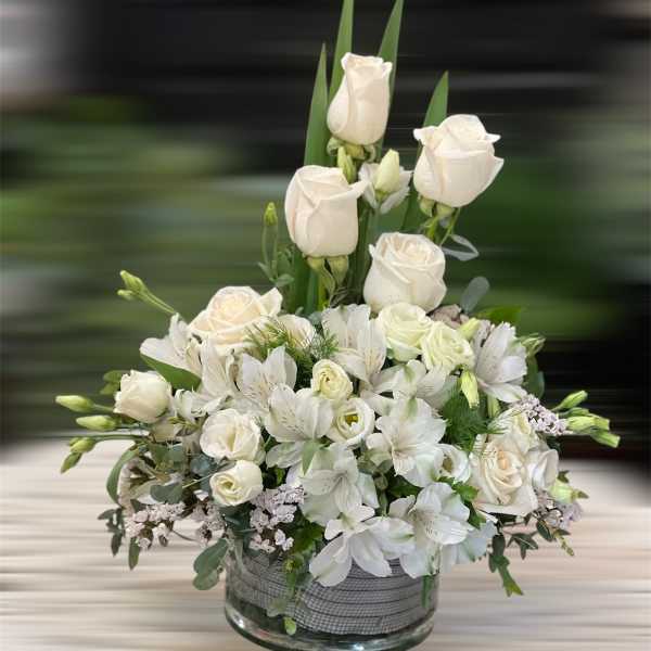 White roses and lilies arranged in a glass vase