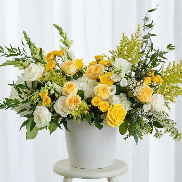 Yellow and white roses in a white vase