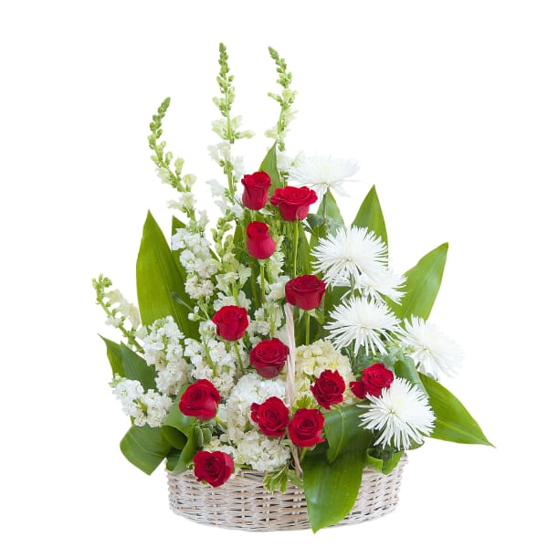 Basket arrangement of red roses and white flowers in a white wicker basket
