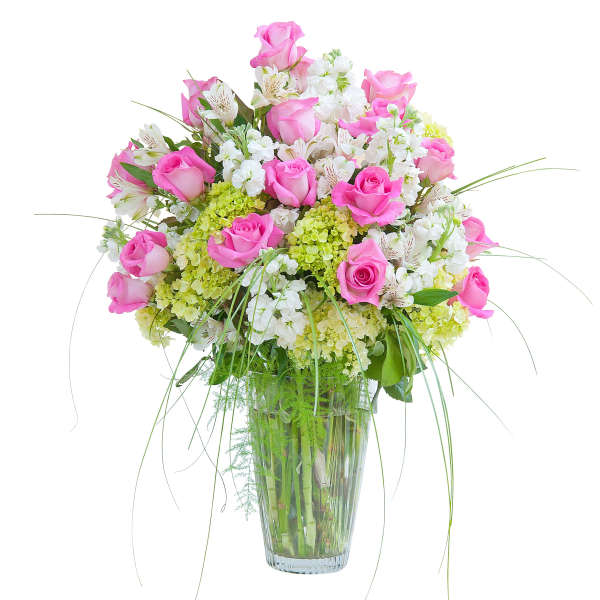 Tall vase arrangement of pink roses with white flowers and green hydrangeas