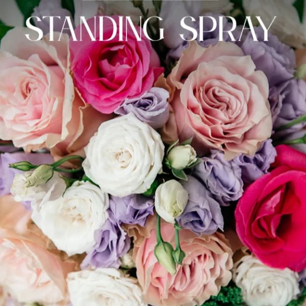 Standing spray of pink, white, and lavender roses with green accents