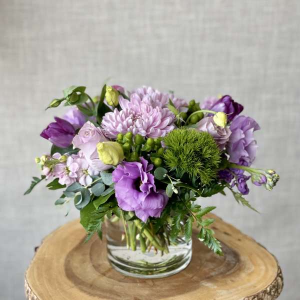 Purple and pink mixed bouquet in a clear glass vase