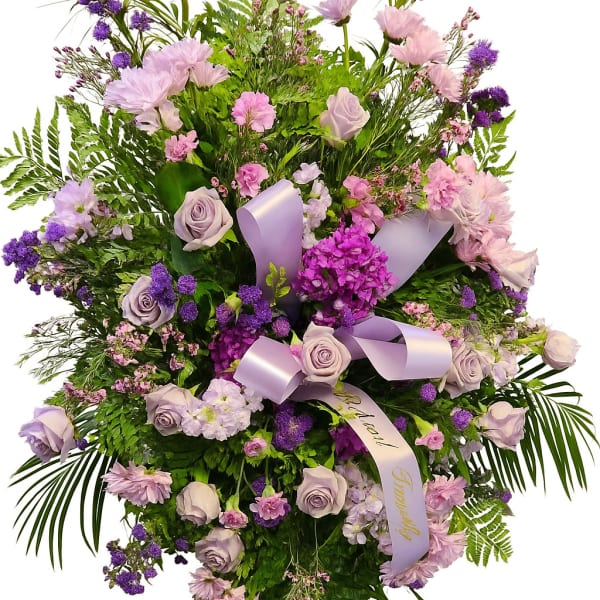 Lavender and pink floral spray with ribbon on a white background