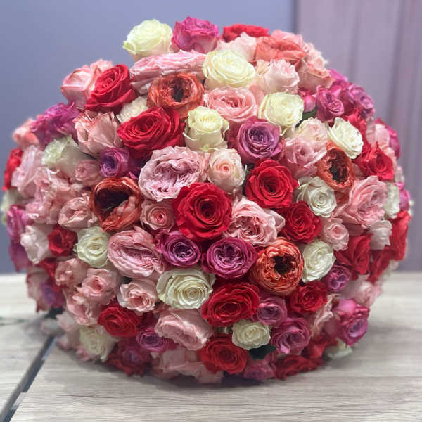 Large round bouquet of pink, red, white, and purple roses