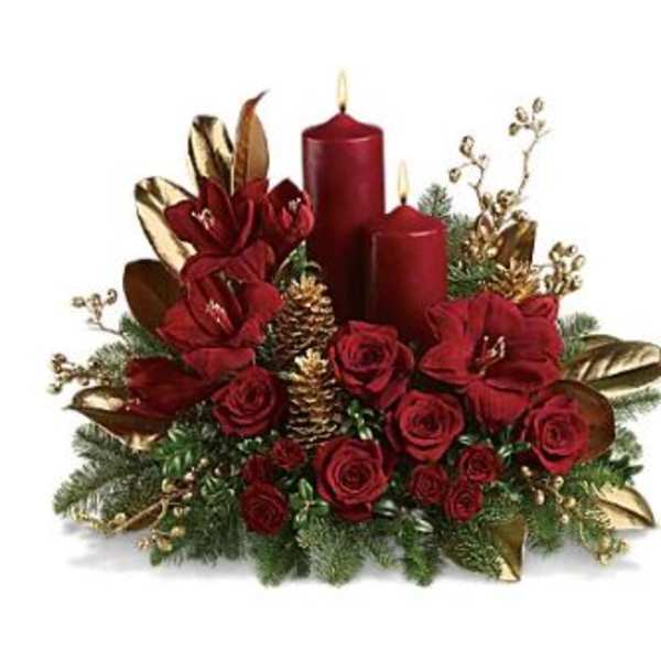 Red roses with candles and gold accents in a holiday centerpiece