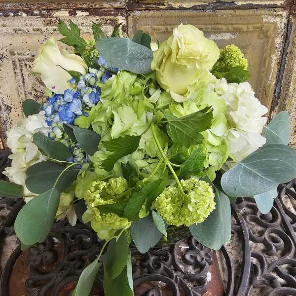 Bouquet of pale green and white flowers with blue accents