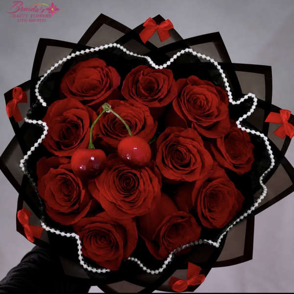 Bouquet of red roses wrapped in black paper with pearl trim and red bows