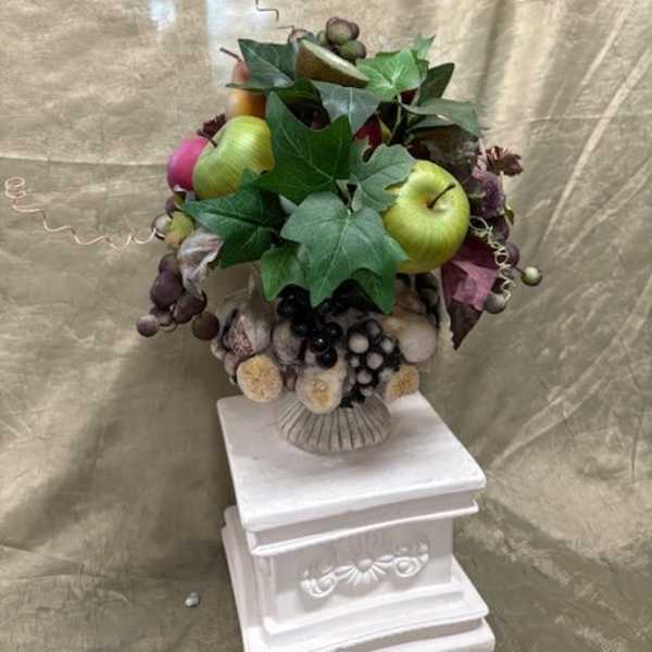 Fruit arrangement with apples and grapes in a decorative vase
