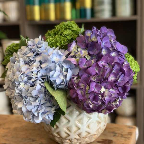 Blue and purple hydrangeas in a patterned ceramic vase