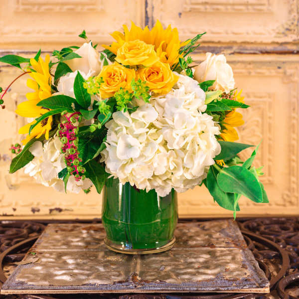 Yellow sunflowers and white hydrangeas in a glass vase
