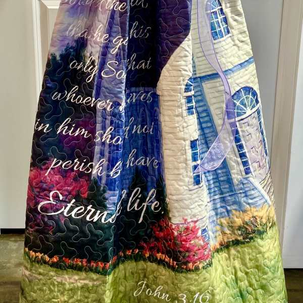 Quilted blanket with a church print and purple ribbon bow