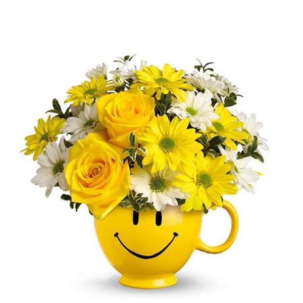 Yellow roses and daisies in a smiley-face mug