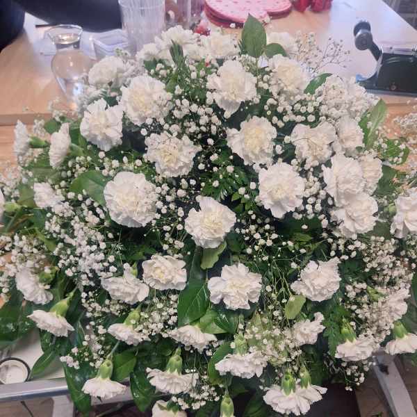 Large white carnation arrangement with baby's breath and greenery