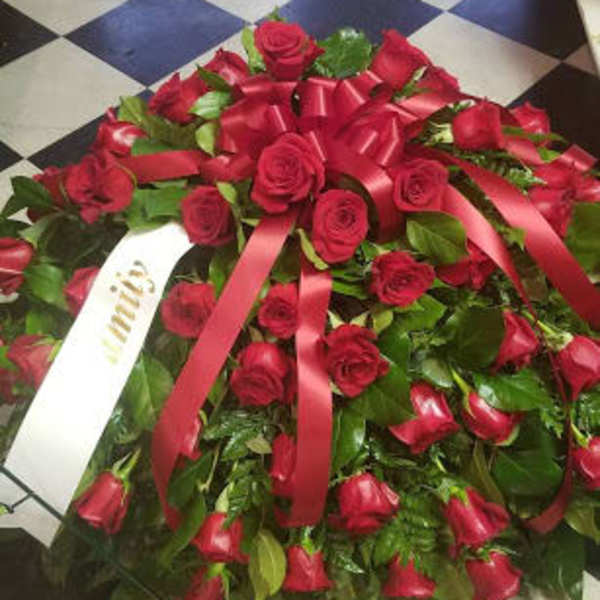 Large red rose wreath with satin ribbons on a checkered floor