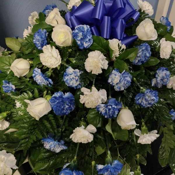 Blue and white floral arrangement with a large blue ribbon bow
