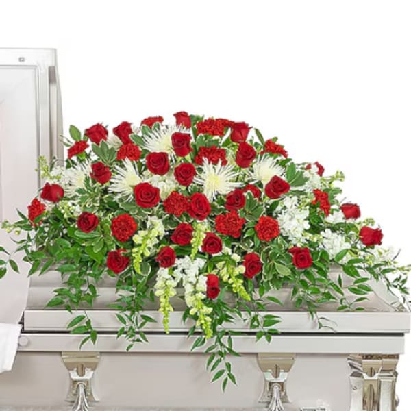 Red roses and white flowers arranged on a casket