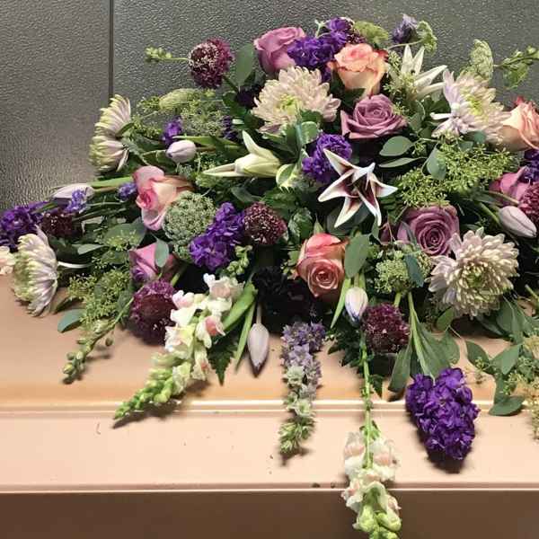 Large casket spray with pink, purple, and white flowers