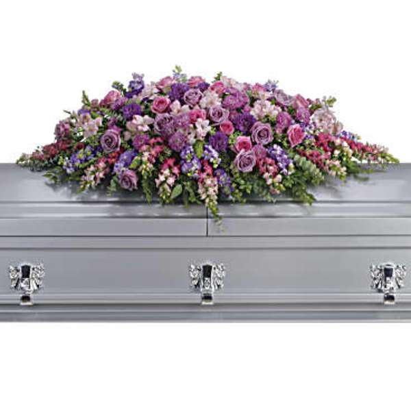 Lavender and pink floral casket spray on a silver casket