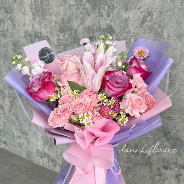 Pink and lavender bouquet with roses, lilies, and small daisies