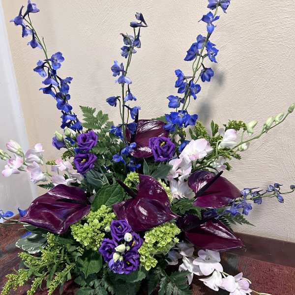 Purple and blue floral arrangement with tall spikes and dark calla lilies