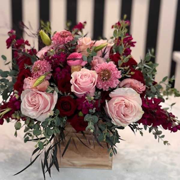 Pink and red rose arrangement in a wooden box