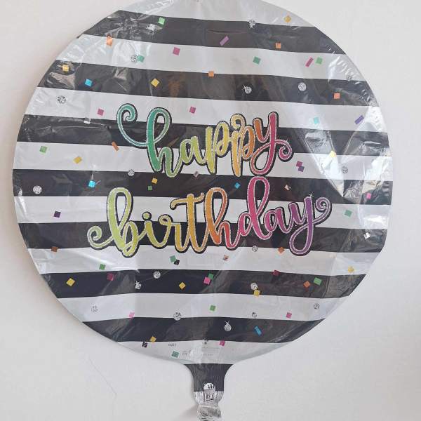 Round birthday balloon with black-and-white stripes and colorful confetti text