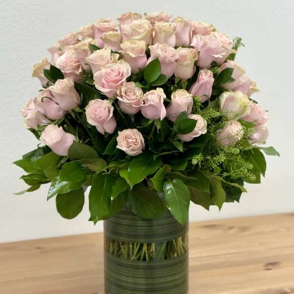 Pink roses arranged in a green glass vase