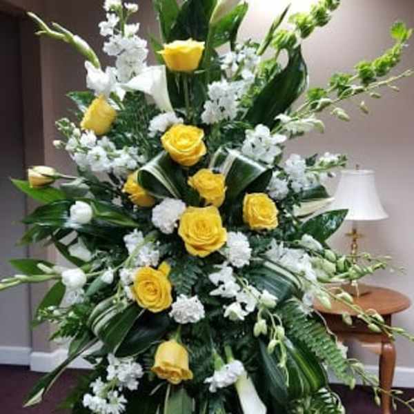 Tall yellow and white floral standing spray on an easel